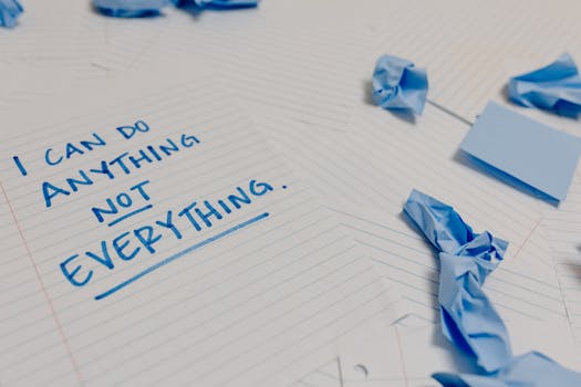 Motivational message on a page surrounded by crumpled papers and blue sticky notes.